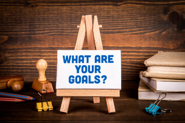 Wall Mural - What are your goals? Text on a miniature easel. Dark textured background