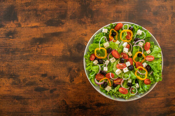 Wall Mural - top view green salad with vegetables and feta in a plate on a table