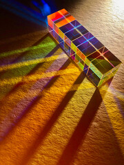 A row of square dichroic glass cubes diffusing beam of light into many color spectrums. Colourful lighting with shade and shadow. Reflection inside glass cube is creative.