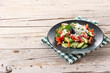 Traditional Bulgarian shopska salad with tomato,cucumber and bulgarian sirene cheese on wooden table. Copy space