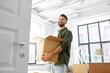 © Syda Productions - moving, people and real estate concept - happy smiling man holding box with stuff at new home