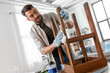© Syda Productions - renovation, diy and home improvement concept - man degreasing old round wooden table surface with tissue