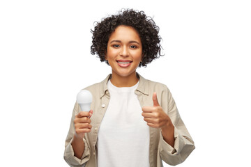 Wall Mural - eco living, energy saving and sustainability concept - portrait of happy smiling woman holding lighting bulb over white background