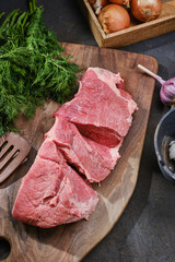 Wall Mural - Fresh cut of beef on wooden kitchen board with spices, garlic and onions. Raw steak on cutting board ready to cook. Selective focus