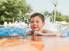 Cheerful Boy In Swimming Pool In Summer