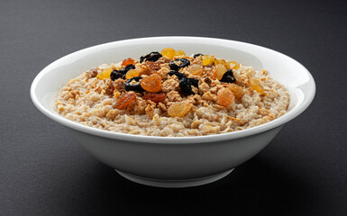 Wall Mural - Bowl of oatmeal on black background 