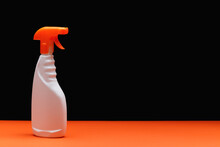Unlabeled White Trigger Spray Bottle With Orange Sprinkler.