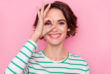 portrait of attractive cheerful girl showing ok-sign like watch look see isolated over pink pastel c