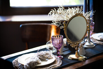 Retro vintage table. Arrangement on the table, antique mirror, plates, vintage mug. Ancient mirror on the table