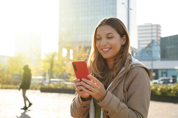 Canvas Print - Portrait of girl outdoor using smartphone wearing winter coat watching video streaming