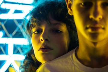 Wall Mural - Portrait of a young generation z couple in neon lighting.