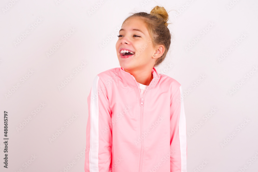 caucasian little kid girl with bun hairstyle wearing pink tracksuit ...