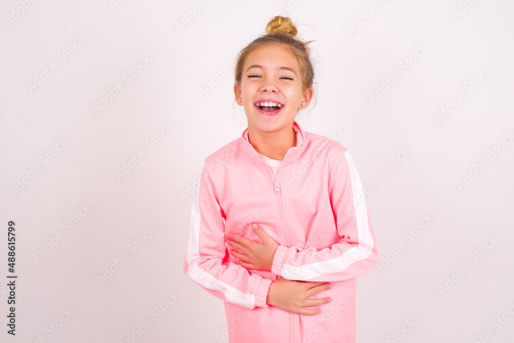 caucasian little kid girl with bun hairstyle wearing pink tracksuit ...