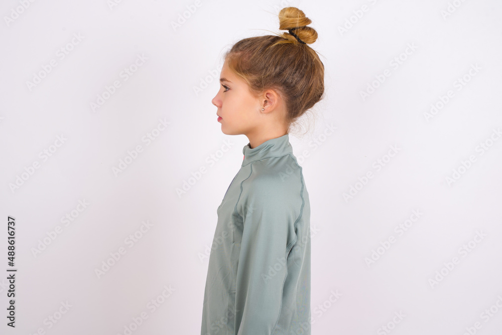 little caucasian kid girl with hair bun wearing technical shirt over ...