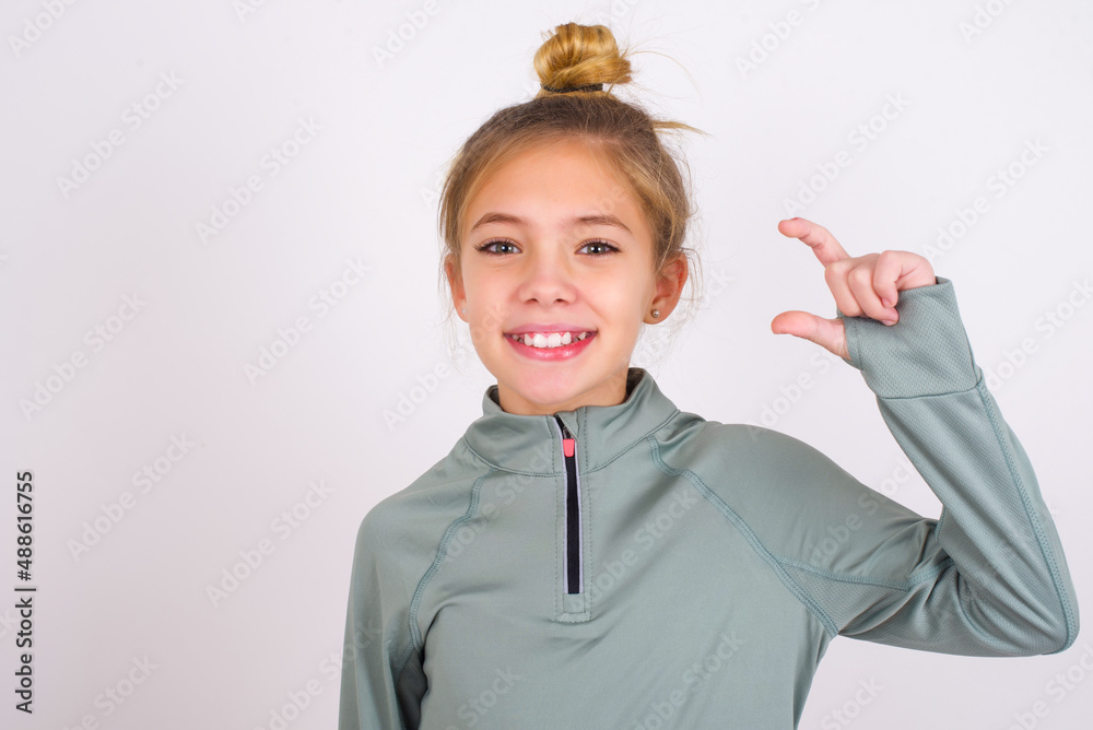 little caucasian kid girl with hair bun wearing technical shirt over ...