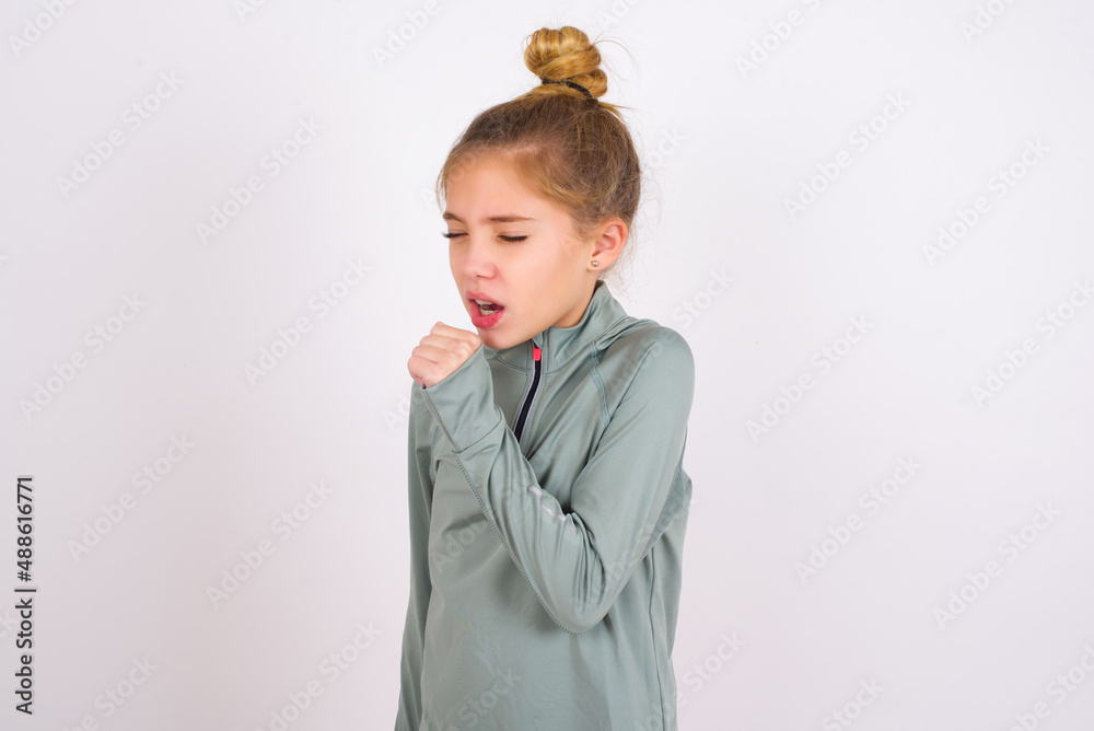 little caucasian kid girl with hair bun wearing technical shirt over ...