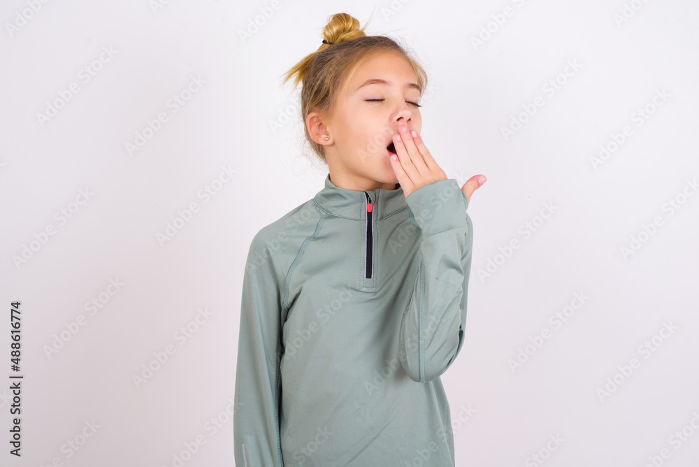 little caucasian kid girl with hair bun wearing technical shirt over ...