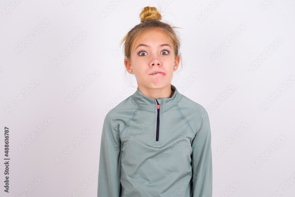little caucasian kid girl with hair bun wearing technical shirt over ...