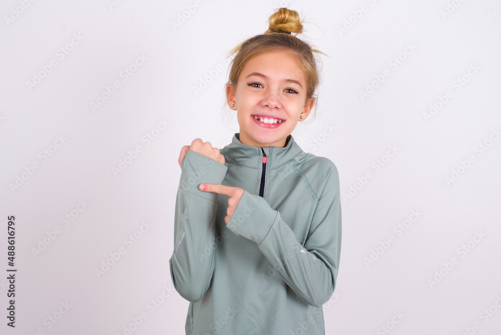 little caucasian kid girl with hair bun wearing technical shirt over ...