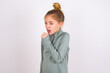 © Roquillo - little caucasian kid girl with hair bun wearing technical shirt over white background feeling unwell and coughing as symptom for cold or bronchitis. Healthcare concept.