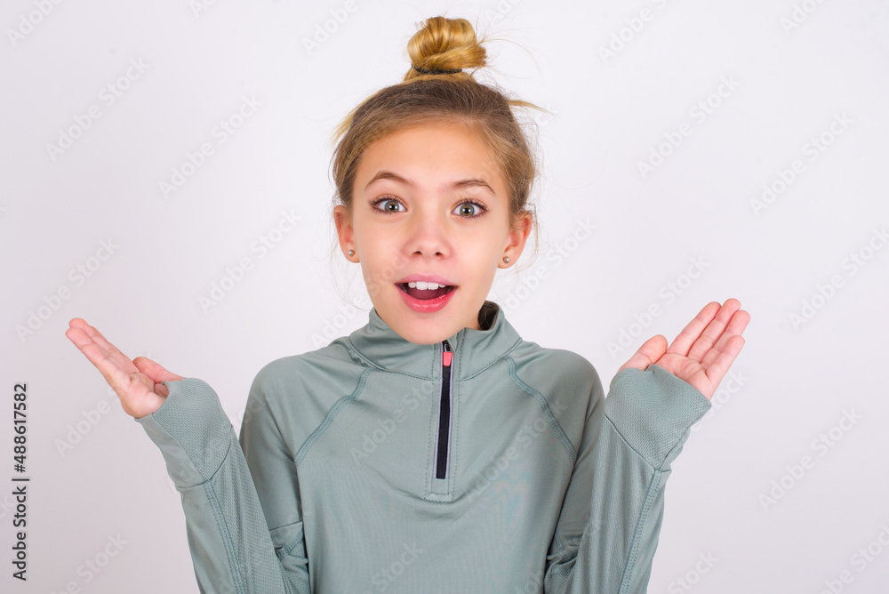 Surprised terrified little caucasian kid girl with hair bun wearing ...