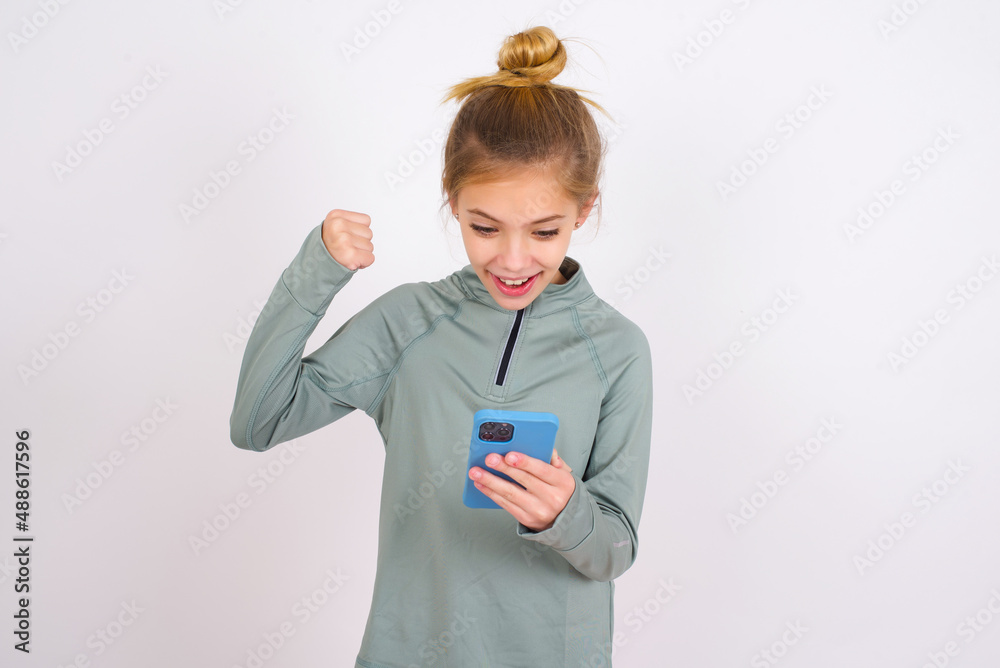 little caucasian kid girl with hair bun wearing technical shirt over ...
