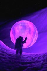 Wall Mural - silhouette of the toy of astronaut against levitating glowing sphere over surface icy planet covered