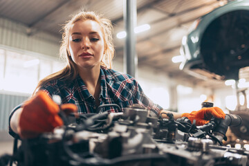 Destroying gender stereotypes. Young woman auto mechanic working at auto service station using different work tools. Gender equality. Work, occupation, car