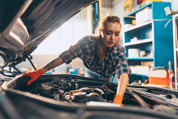 Destroying gender stereotypes. Young woman auto mechanic working at auto service station using different work tools. Gender equality. Work, occupation, car