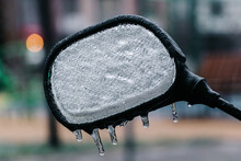 Rear View Mirror Of A Motorcycle Parked On The Street During Freezing Rain