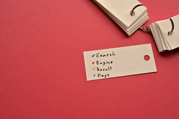 Poster - There is a small card placed on a red background paper with the word Search Engine Result Page written on it. Copy space available.