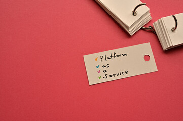 Poster - There is a small card placed on a red background paper with the word Platform as a Service written on it. Copy space available.
