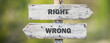 © Jon Anders Wiken - opposite signs on wooden signpost with the text quote right wrong engraved. Web banner format.
