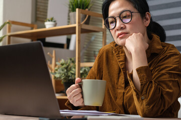 Poster - asian woman drink coffee cup and watching live streaming on laptop when work at home