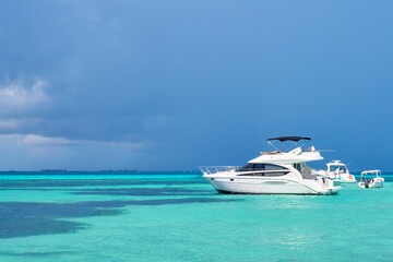yacht in north beach of isla mujeres, cancun, mexico.blue sky with rain nearby and turquoise blue se