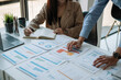 © Natee Meepian - Business Asian People Discussing with coworker planning analyzing financial document data charts and graphs in Meeting and successful teamwork Concept