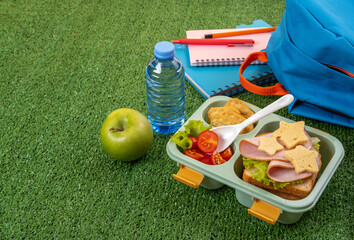 Wall Mural - Healthy school lunch box with sandwich and salad at school yard. School supplies, books, apple and a bottle of water. Back to school