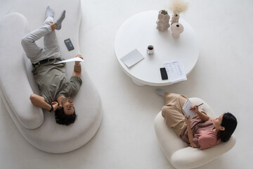 Aufkleber - Overview of two young specialists in casualwear discussing financial data while woman making notes and man analyzing information