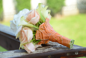 Wall Mural - A bridal boquet with callas and roses on a wooden surface