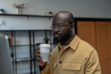 Aufkleber - Young serious office manager with drink looking at data on computer screen while sitting in front of monitor by workplace