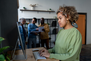 Aufkleber - Young pretty biracial businesswoman looking at computer screen while preparing for presentation or analyzing financial data