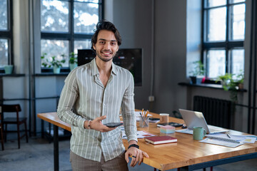 Aufkleber - Young smiling employee in striped casual shirt standing by workplace against table with financial papers and other supplies