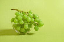 A Bunch Of Green Grapes In A Glass Bowl On A Colored Background