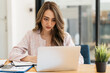 © PaeGAG - Happy attractive Asian business woman working with a laptop and financial document at office, successful action, Business concept.