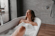© Prostock-studio - Peaceful lady enjoying warm bath with soap bubbles, relaxing in bathtub with closed eyes after hard day, free space