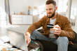 © Prostock-studio - Cheerful Man Shopping Online Using Laptop And Credit Card Indoor
