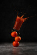 Food levitation. Three tomatoes stacked on each other balancing and a glass with tomato juice with splashes flying in the air
