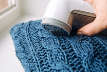 Removing Shaving Lint Fuzz From Blue Woolen Coat Sweater, Wool Clothes Maintain Concept.