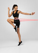 © opolja - Sportswoman exercising with resistance band. Female with working out with elastic band on white background