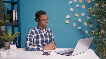 Wall Mural - call center worker talking to client on headset with microphone, helping with telemarketing and sale